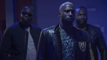 La veste en cuir bleu marine noir foncé avec écusson lions en or Richard Valentine Paris dans le clip Validé (B.O de la série Validé) de Sam's feat Lacrim