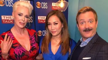 Veronica beard Red Flo­ral Asym­met­ric Ruched Dress worn by Brigitte Nielsen on The Talk March 10, 2020