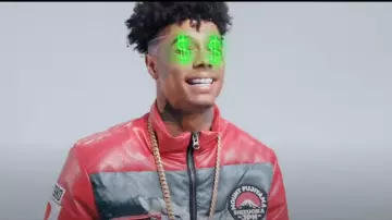 Iro Ochi Moun­tain Print Red Puffer Jack­et worn by Blueface in his Tour music video (feat. Asian Doll, Glokk 9, NLE Choppa, Sada Baby & Kiddo Curry)