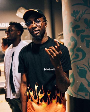 The t-shirt Palm Angels flame carried by Dopebwoy on his account Instagram @dopebwoy