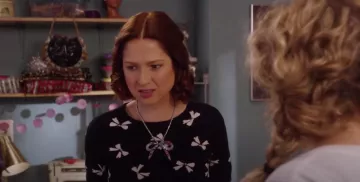 Top negro con lazo blanco usado por Kimmy Schmidt (Ellie Kemper) en Unbreakable Kimmy Schmidt: Kimmy vs. the Reverend