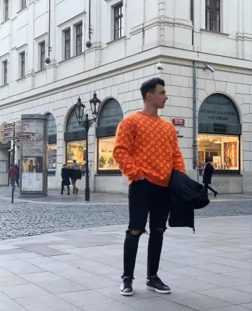 The sweater Louis Vuitton Sweater Monogram orange worn by Chris Dedi during his trip to Prague