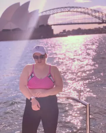 Nike Training Indy logo taped bra in pink worn by Rebel Wilson on the Instagram account @rebelwilson
