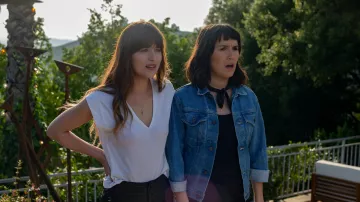 La camiseta blanca de cuello en V que lleva Maggie Sherwoode (Dakota Johnson) en La Voz del Éxito