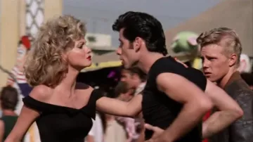 Le top noir épaules dénudées porté par Sandy (Olivia Newton-John) dans le film Grease