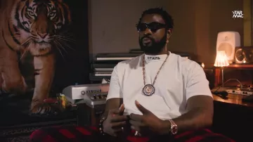 Pantalon rouge et noir de Damso dans la vidéo Damso : Interview exclusive en direct de Kinshasa pour la sortie de QALF !