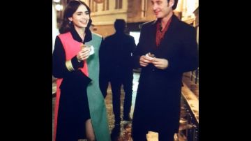 Emily in paris: Coat black, pink and grey. The sleeves are black, half coat grey and half pink and black. Is knee lenght.