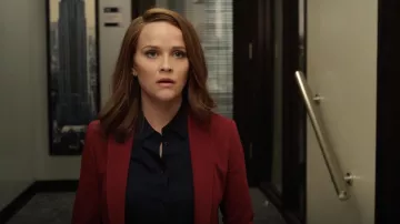 Bloua esencial de equipo en negro usada por Bradley Jackson (Reese Witherspoon) como se ve en la serie de televisión The Morning Show (Temporada 2 Episodio 1)
