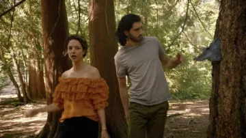 Alice + Olivia Ersa Off-Shoulder Tiered Ruffle Blouse en naranja usada por Zari Tomaz (Tala Ashe) como se ve en Legends of Tomorrow de DC (S07E01)