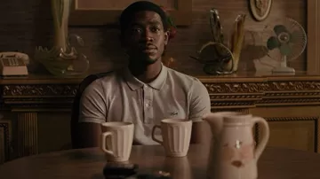 Polo gris Lacoste usado por Franklin Saint (Damson Idris) como se ve en el programa de televisión Snowfall (S05E01)