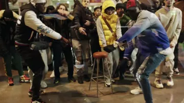 Chaqueta amarilla de Larry con parche del logotipo de Moncler sin mangas en su clip EN PÉPÉ 2