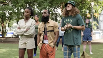 Nike Fleece Shorts en orange porté par Clovis (T. Murph) comme on le voit dans les tenues de la série télévisée Woke (Saison 2 Episode 1)