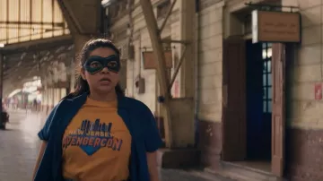 New Jersey Avenger Con T-Shirt en orange porté par Kamala Khan (Iman Vellani) dans la garde-robe de la série télévisée Ms. Marvel (Saison 1 Episode 4)