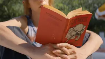 Strangers on a Train book by Patricia Highsmith read by Eleanor (Maya Hawke) in Do Revenge movie