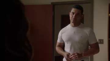 T-shirt AllSaints en blanc porté par Nick Torres (Wilmer Valderrama) tel que vu dans les tenues de la série télévisée NCIS (saison 20 épisode 3)