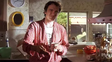 Smiling gloves white tee worn by Quentin Tarantino as seen in Pulp Fiction
