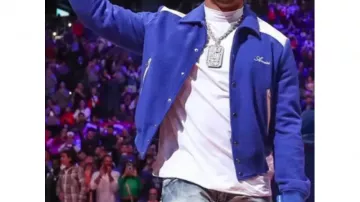Amiri Varsity Jacket en bleu porté par Jalen Hurts avant le match NBA Sixers VS Spurs le 21 octobre 2022