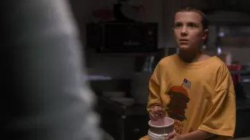 Yellow Benny's Burger T-Shirt worn by Eleven (Millie Bobby Brown) in Stranger Things (Season 1 Episode 1)