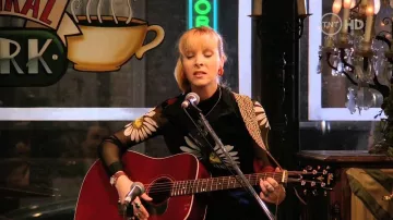 Robe en maille majestueuse florale en noir portée par Phoebe Buffay (Lisa Kudrow) dans la série télévisée Friends (S02E18)