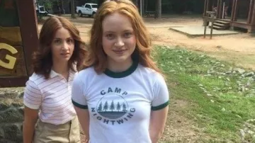 Camisa de manga verde y cuello de Camp Nightwing usada por Sadie Sink en el set de Fear Street: película de 1978 Parte 2