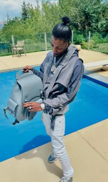 Dior Grey Maxi Gallop Backpack worn by YoungBoy Never Broke Again on the Instagram account @nba_youngboy
