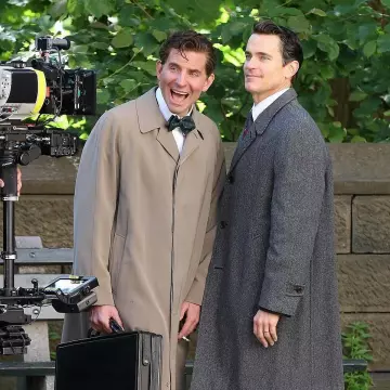 Manteau de tranchée gris porté par Bradley Cooper interprétant Leonard Bernstein sur le tournage du film Maestro