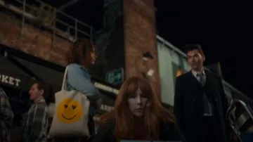 Asos design Tote Bag with Hap­py Face Print worn by Yasmin Finney as seen in Doctor Who (S14E01)