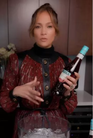 Vestido plisado Coach Burgundy usado por Jennifer Lopez en su publicación de Instagram el 19 de noviembre de 2023