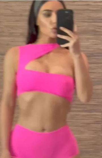 Skims Fits Everybody Cut out Super Cropped Top in Neon Pink worn by Kim Kardashian on her Instagram Story on June 12, 2023