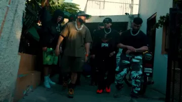 Camiseta Helmut Lang Brown & Yellow Space Logo usada por El Alfa en Tiagz X Fuerza Regida X El Alfa - TACATA (REMIX) [Video Oficial]