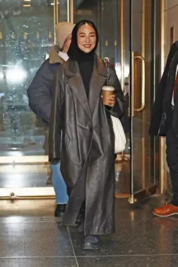 Manteau plissé Loewe en cuir d’agneau Nappa porté par Greta Lee à New York le 20 décembre 2023