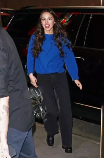 Celine Medium Besace Triomphe En Cuir de Veau Naturel Souple Noir porté par Olivia Rodrigo au Leaving Jingle Ball le 9 décembre 2023