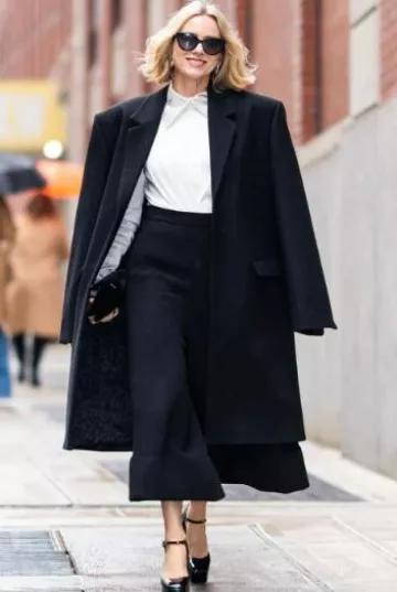 Manteau midi oversize Magda Butrym en noir porté par Naomi Watts au Drew Barrymore Show le 23 janvier 2024