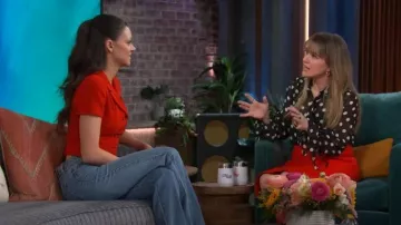 Chaqueta corta con botones con logotipo rojo de Chanel usada por Nicola Peltz como se ve en The Kelly Clarkson Show el 9 de febrero de 2024