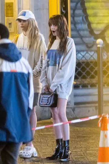 Paco Rabanne Bottines noires portées par Lily Collins sur le tournage de la saison 4 de la série Netflix « Emily in Paris » à Paris - 15 février 2024