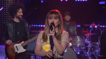 Camiseta gráfica Smiley Split Nirvana Split de Merch Traffic usada por Kelly Clarkson como se ve en The Kelly Clarkson Show el 28 de marzo de 2024