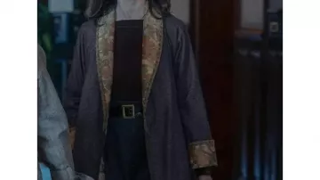 La garde-robe de la série télévisée New Look : Elsa Lombardi (Emily Mortimer) porte un long manteau gris dans la saison 1, épisode 2