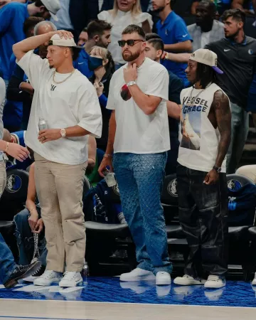 Camiseta blanca con estampado de manzana de Nahmias usada por Travis Kelce en la cuenta de Instagram @blitzfits