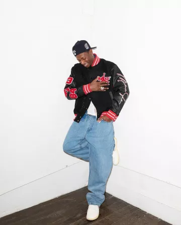 Jordan X Awake NY Black & Red Varsity Jacket worn by Joey Bada$$ on the Instagram account @joeybadass