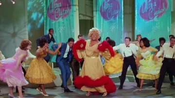 Garde-robe de film de laque : Queen Latifah porte une robe dorée à volants rouges pour représenter Motormouth Maybelle