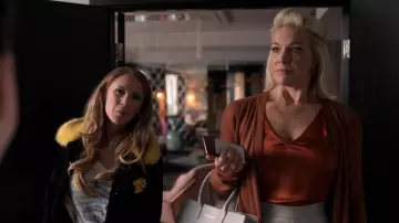 Vestuario de Ted Lasso: Juno Temple usa chaqueta negra con piel amarilla y decoración dorada para interpretar a Keeley Jones en la temporada 1, episodio 7 de la serie de televisión