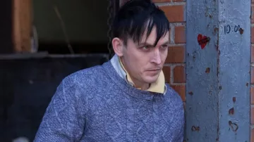 Tenues de la série télévisée Gotham : Oswald Cobblepot (Robin Taylor) porte un pull en tricot torsadé bleu clair dans la saison 1, épisode 3
