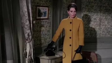 Tenues de film Charade : Audrey Hepburn porte un manteau jaune moutarde Christine Kennedy pour représenter Regina Lampert