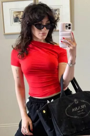 Bolso de mano con el logotipo de Prada Canapa usado por Niki Demartino en su historia de Instagram el 28 de agosto de 2024