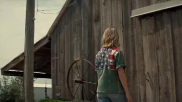 Looks de la película Twisters: Kate (Daisy Edgar-Jones) lleva una camisa verde con la bandera estadounidense en la espalda