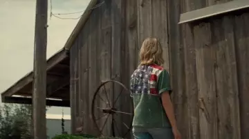 Looks from the movie Twisters: Kate (Daisy Edgar-Jones) wears a green shirt with the American flag on the back