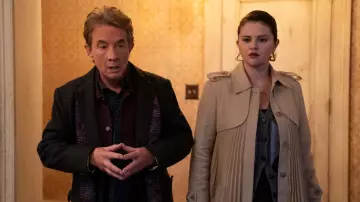 Tenues de la saison 4 de Only Murders In The Building : Selena Gomez porte un long manteau plissé beige dans l’épisode 2 pour incarner Mabel Mora dans la série télévisée