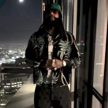 Sombrero de pescador con logotipo de triángulo verde de Prada usado por Money Man en la cuenta de Instagram @moneyman_head