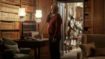 Serie de televisión A Very Royal Scandal: El príncipe Andrés (Michael Sheen) lleva un suéter rojo en el episodio 1 de la temporada 1