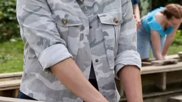 Atuendos de la película The Real West: Rebecca (Kimberly Sustad) lleva una chaqueta de camuflaje gris